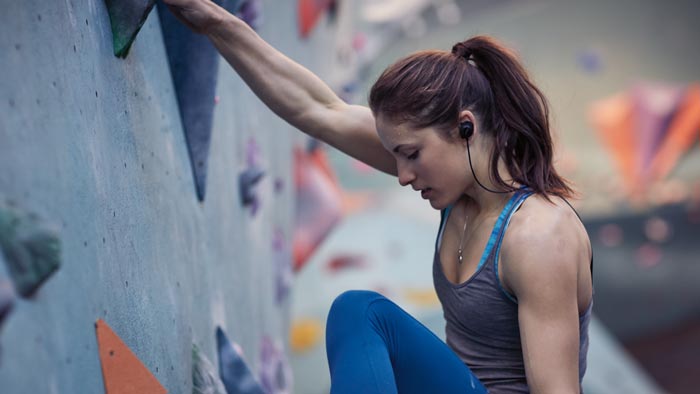 Image of SoundSport wireless worn by woman on climbing wall.
