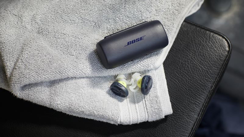 Image of a man sitting on stairs. Bose SoundSport Free wireless headphones.