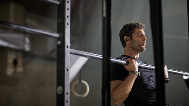 Image of a man sitting on stairs. Bose SoundSport Free wireless headphones.
