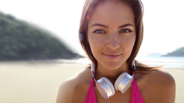 Girl wearing Cleer BT headphones standing on beach